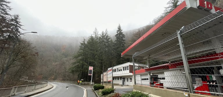 Foto der abgesperrten Tankstelle in Bad Bertrich. Man sieht auch die Straße und im Hintergrund den Wald. Die Tankstelle ist nach einem Hangrutsch geschlossen. (Foto: SWR)
