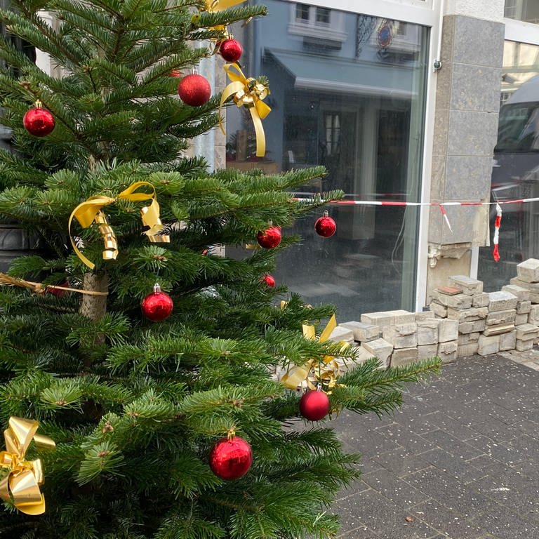 Ein Weihnachtsbaum steht in der Fußgängerzone von Bad Neuenahr-Ahrweiler, in der noch viele Geschäfte von der Flut zerstört sind. (Foto: SWR)
