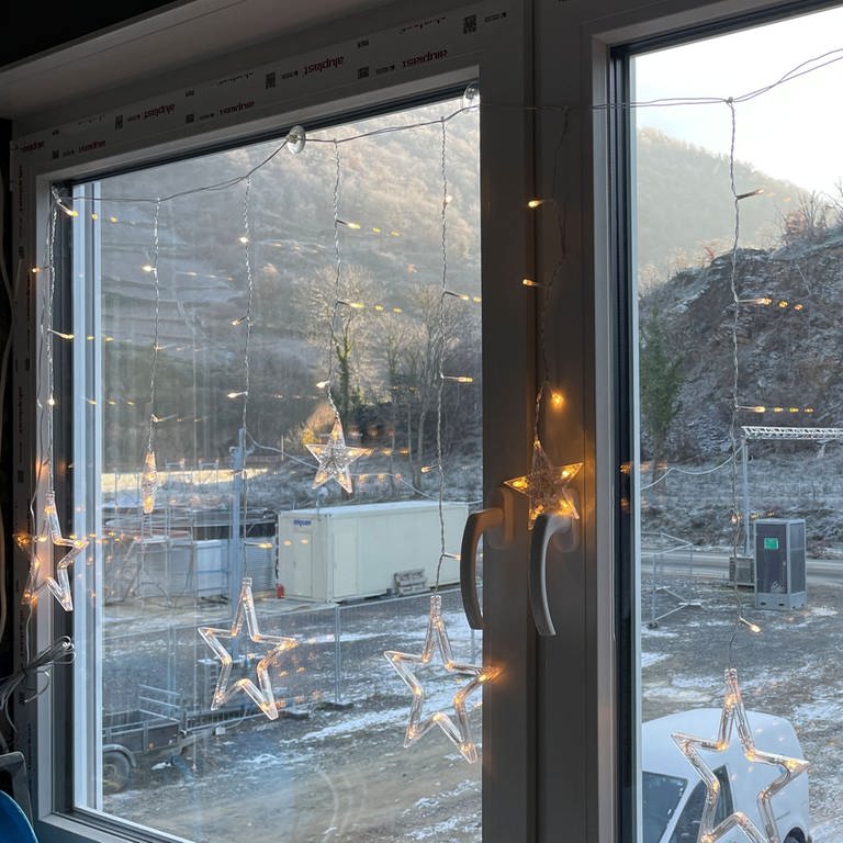 Beleuchtete Weihnachtssterne hängen in einem Fenster, aus dem man auf das winterliche Ahrtal blickt  (Foto: SWR)
