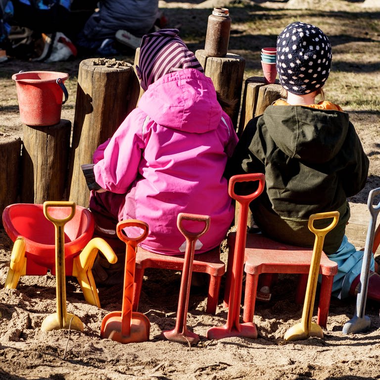 Zwei Kinder sitzen draußen im Sandkasten einer Kita und spielen (Foto: picture-alliance / Reportdienste, Picture Alliance)