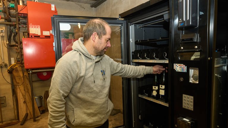 Winzer Peter Klaus aus Ernst an der Mosel steht vor seinem Wein-Automaten, den er wegen Jugenschutz-Bedenken nicht aufstellen darf. (Foto: dpa Bildfunk, Picture Alliance)