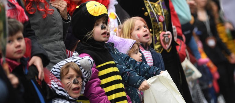 Kinder und Erwachsene stehen verkleidet am Rand eines Karnevalsumzugs. (Foto: picture-alliance / Reportdienste, Federico Gambarini)