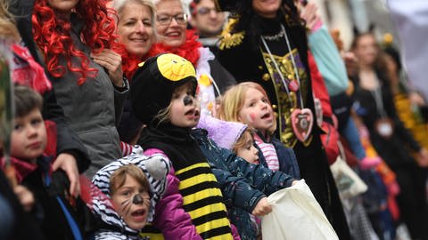 Kinder und Erwachsene stehen verkleidet am Rand eines Karnevalsumzugs. (Foto: picture-alliance / Reportdienste, Federico Gambarini)