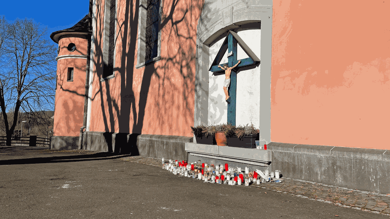 Kerzen stehen vor der katholischen Pfarrkirche in Wissen im Kreis Altenkirchen. Nach der mutmaßlichen Brandstiftung in der Kirche sind die Menschen schockiert und traurig.  (Foto: SWR)