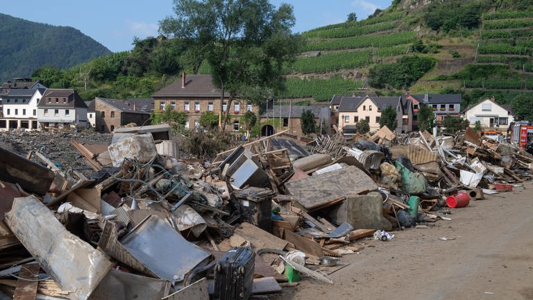 Müll, Treibgut und Unrat liegen am Ufer der Ahr in Mayschoß. Zahlreiche Häuser in dem Ort wurden komplett zerstört oder stark beschädigt. (Foto: dpa Bildfunk, picture alliance/dpa | Julia Cebella)