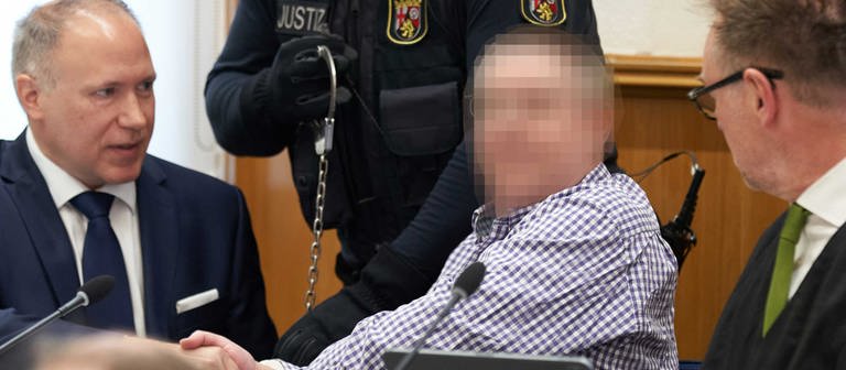 Einer der Angeklagten im Prozess gegen die sogenannten Vereinten Patrioten sitzt mit seinen Verteidigern auf der Anklagebank im Oberlandesgerich Koblenz (Foto: dpa Bildfunk, picture alliance/dpa/dpa POOL | Thomas Frey)
