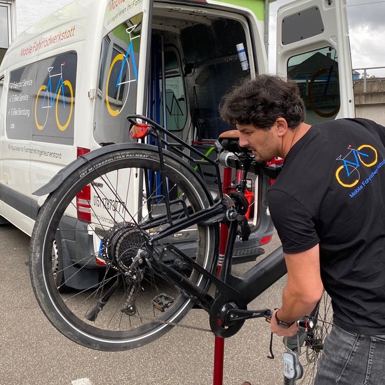 Nico untersucht bei einem Termin mit seiner mobilen Fahrradwerkstatt das E-Bike eines Kunden. (Foto: SWR)