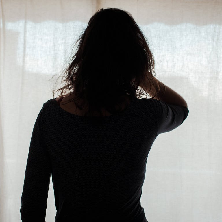 Eine Frau schaut aus einem Fenster mit Vorhang: Nach dem Mord an einer mutmaßlichen Prostituierten in Koblenz schlägt eine Beratungsstelle Alarm - die Gewalt gegen die Frauen nehme deutlich zu. (Foto: IMAGO, IMAGO/ Hans Lukas Bildnummer: 0110308255)