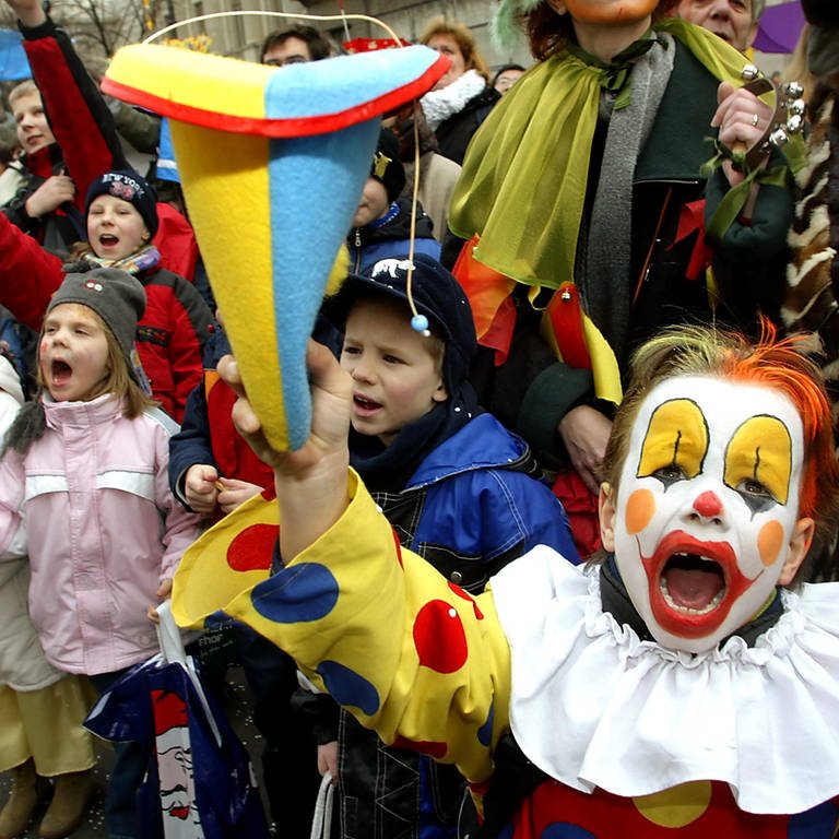 Lauthals "Kamelle" rufend, stehen Kinder am Straßenrand beim Karnevalsumzug. (Foto: picture-alliance / Reportdienste, Wolfgang Kumm)