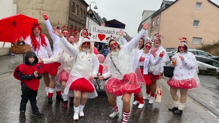 Eine Gruppe Karnevalisten jubeln auf der Straße. Trotz Regen und Kälte - die Narren in Grafschaft-Bölingen haben Karneval im Herzen. (Foto: SWR)