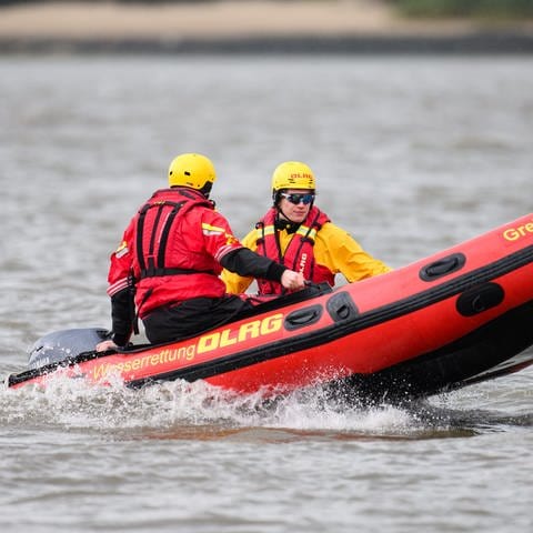 Zwei Retter der DLRG sitzen in einem Schlauchboot - bei Hamm an der Sieg wurde eine Familie mithilfe eines Bootes aus einem Steilhang gerettet. (Foto: dpa Bildfunk, Picture Alliance)