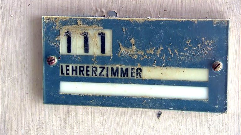 Schlamm an einem Schild mit der Aufschrift "Lehrerzimmer" - 16 Schulen im Landkreis Ahrweiler wurden vom Hochwasser so zerstört, dass sie nach den Sommerferien nicht mehr genutzt werden können.