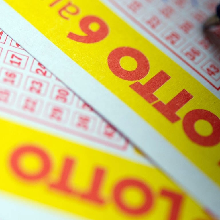 Zwei Lottoscheine, jemand setzt mit einem Kugelschreiber ein Kreuz auf ein Kästchen (Foto: SWR)