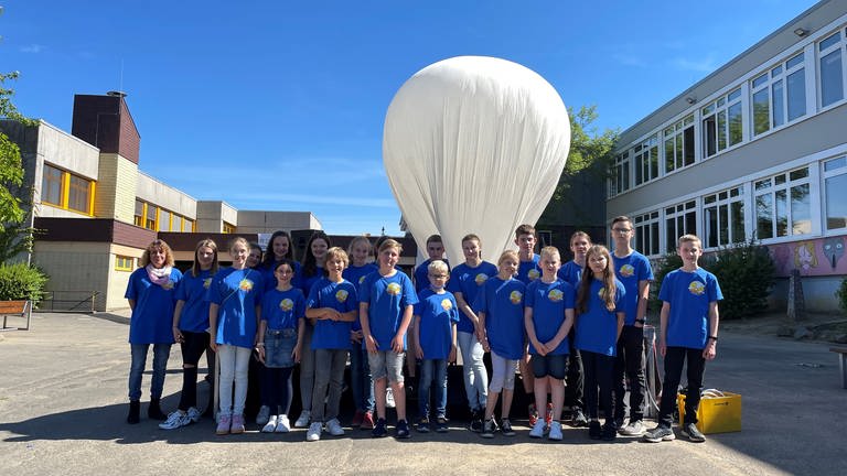 Schüler des Wiedtal-Gymnasium stehen vor dem Wetterballon, den sie in die Stratosphäre steigen lassen wollen. (Foto: SWR)