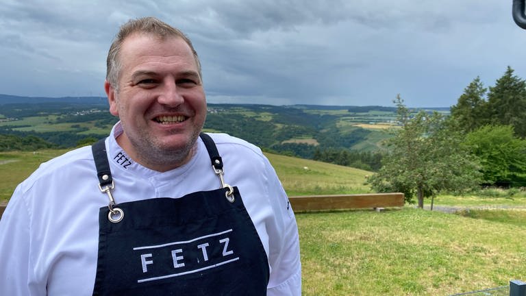 Hotel- und Restaurantfachmann Marcus Fetz mit umgehängter Kochschürze blickt in die Kamera. (Foto: SWR)