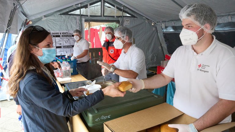 Helfer im Verpflegungszentrums des Deutschen Roten Kreuzes geben Essen an die Opfer der Flutkatastrophe aus. (Foto: dpa Bildfunk, picture alliance/dpa | Thomas Frey)