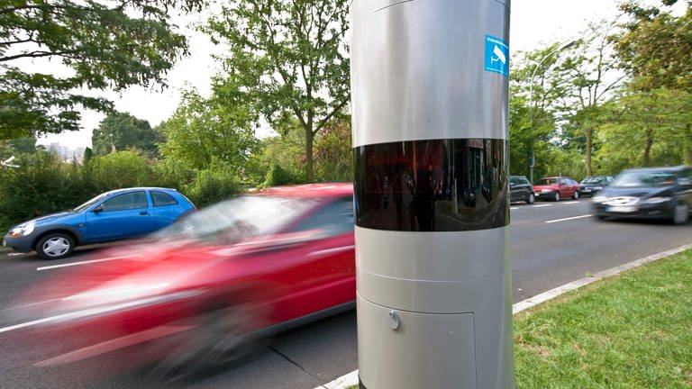 Autos fahren an einer Radarfalle in einer Straße vorbei: Nach einem Urteil des Verfassungsgerichtshofes Rheinland-Pfalz in Koblenz sind Bußgelder auch ohne gespeicherte Rohmessdaten rechtens.  (Foto: picture-alliance / Reportdienste, Picture Alliance)