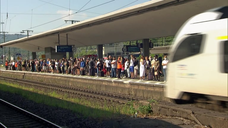 Foto von einem Bahnsteig voller Menschen am Hauptbahnhof Koblenz. Gerade fährt ein Zug ein. Wegen des 9-Euro-Tickets nutzen besonders viele Menschen die Bahn.