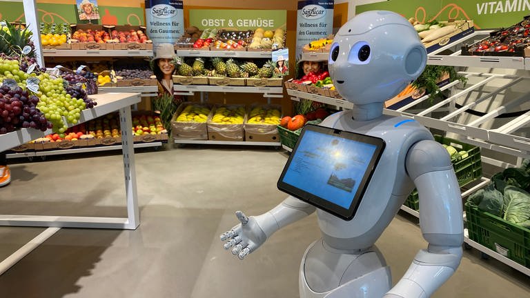Ein Roboter mit einem I-Pad steht in der Gemüseabteilung des Supermarkts