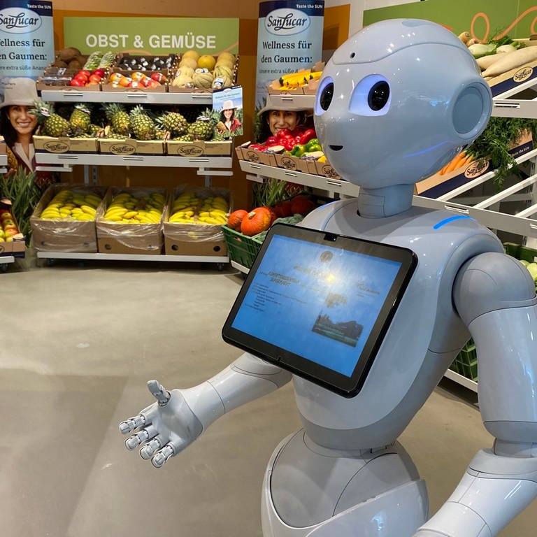 Ein Roboter mit einem I-Pad steht in der Gemüseabteilung des Supermarkts