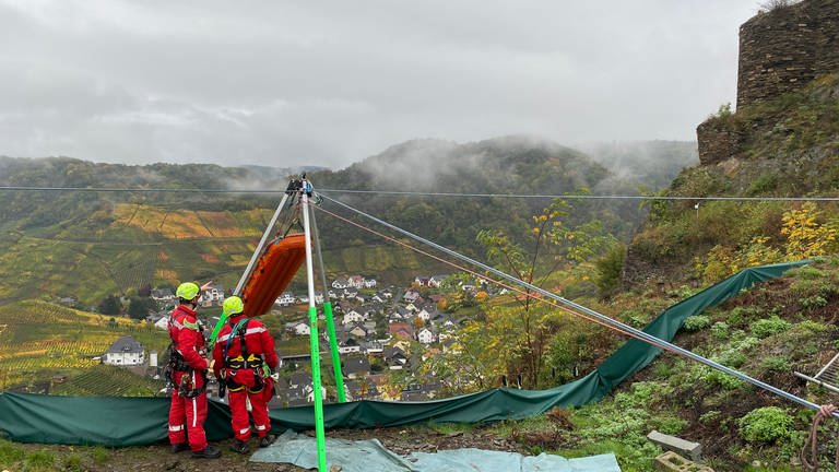 Die Spezialisten der Feuerwehr Frankenthal transportieren die Trauben aus dem Steilhang bei Mayschoss mit einer Seilwinde ab und haben dabei die Station dafür oben auf dem Berg aufgebaut. 