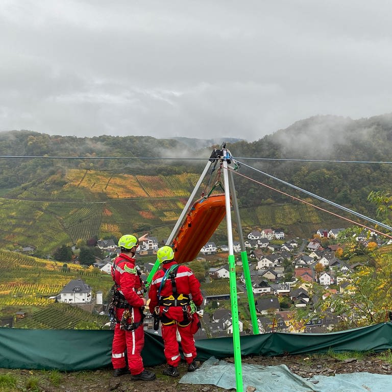 Die Spezialisten der Feuerwehr Frankenthal transportieren die Trauben aus dem Steilhang bei Mayschoss mit einer Seilwinde ab und haben dabei die Station dafür oben auf dem Berg aufgebaut. 