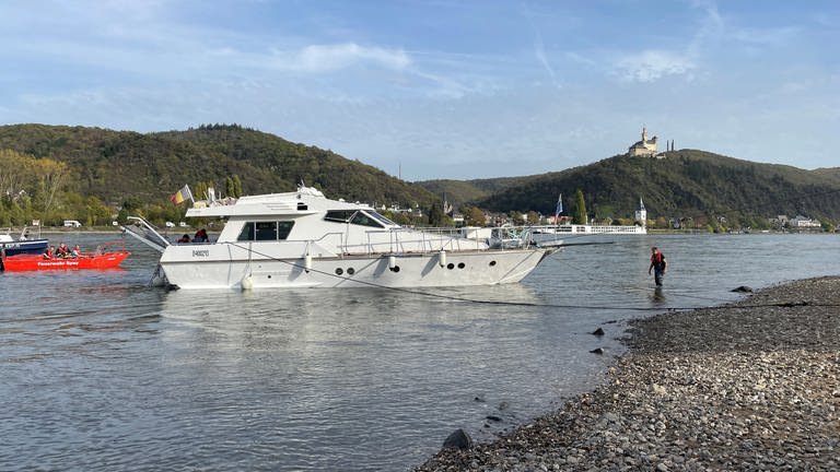 Eine Yacht liegt am Rheinufer bei Brey auf Grund.