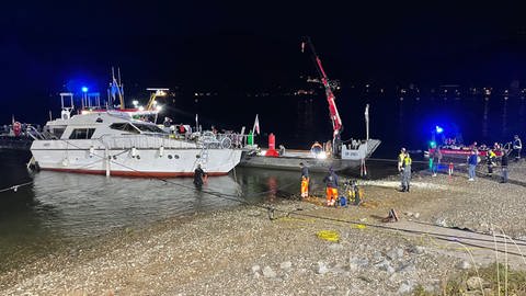 Feuerwehrkräfte und Wasserstraßen- und Schifffahrtsamt sichern eine havarierte und leckgeschlagene Yacht in Brey am Rhein