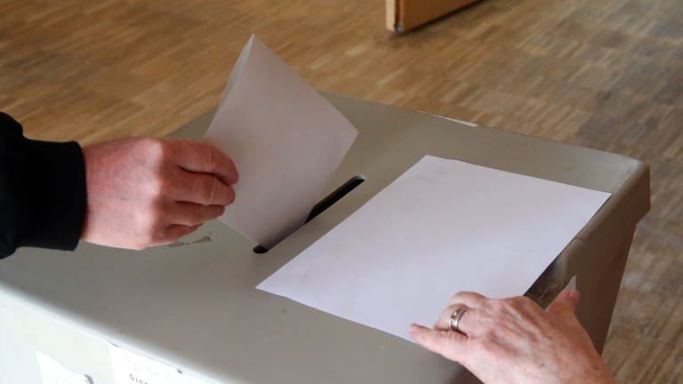 Oberbürgermsiteerwahl in Anxdernach: Wählerin wirft Wahlschein in Wahlurne (Foto: dpa Bildfunk, Picture Alliance)