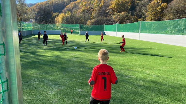 Kinder in roten und schwarzen Trikots spielen auf Fußball-Kleinfeld in Hönningen (Foto: SWR)