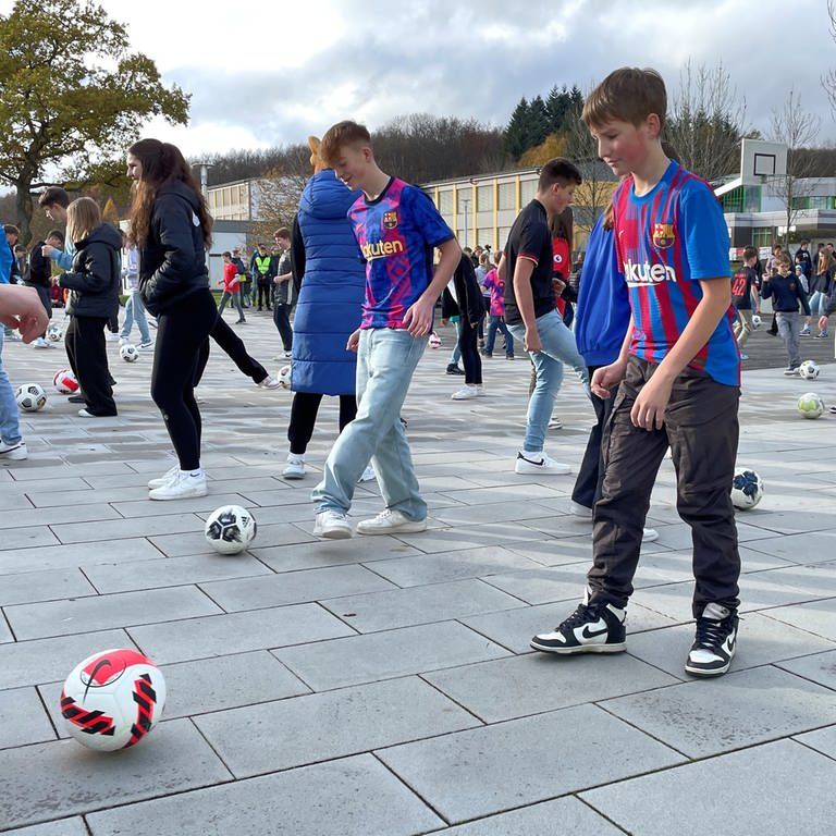 Kinder spielen Fußball auf einem Schulhof in Bad Marienberg
