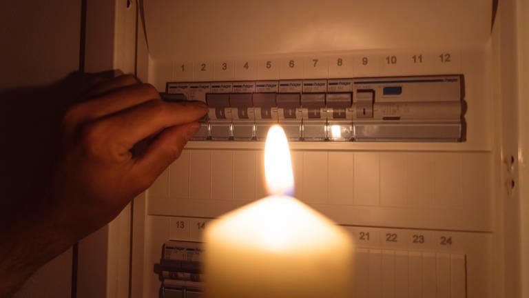 Kerze vor einem Sicherungskasten - die Stadt Koblenz hat einen Notfallplan für den Fall eines längeren Stromausfalles vorgestellt. (Foto: dpa Bildfunk, Picture Alliance)
