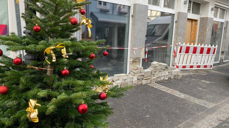 Ein Weihnachtsbaum steht in der Fußgängerzone von Bad Neuenahr-Ahrweiler, in der noch viele Geschäfte von der Flut zerstört sind. (Foto: SWR)