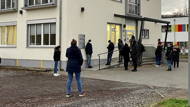 Menschen warten vor der Ärztlichen Bereitschaftspraxis am Kemperhof in Koblenz