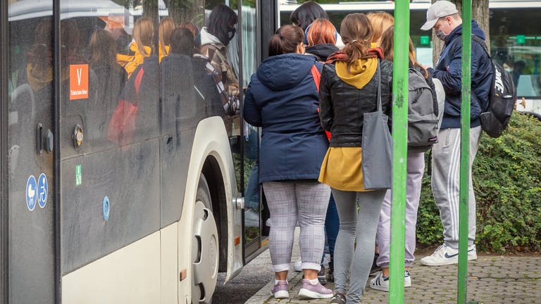 Jugendliche stehen vor einem Bus (Foto: IMAGO, IMAGO / 7aktuell)