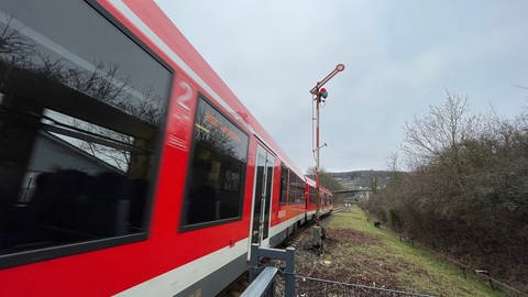 Ein Zug auf der Ahrtalbahn in Richtung Walporzheim neben einem alten Signal aus der Dampflokzeit.