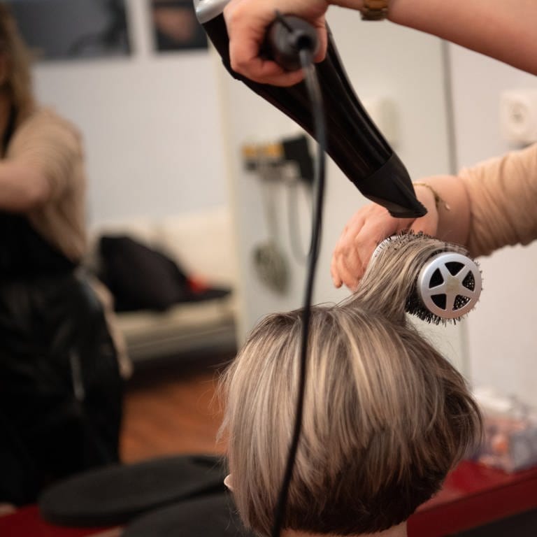 Eine Friseurin föhnt einer Frau die Haare (Foto: picture-alliance / Reportdienste, Picture Alliance)