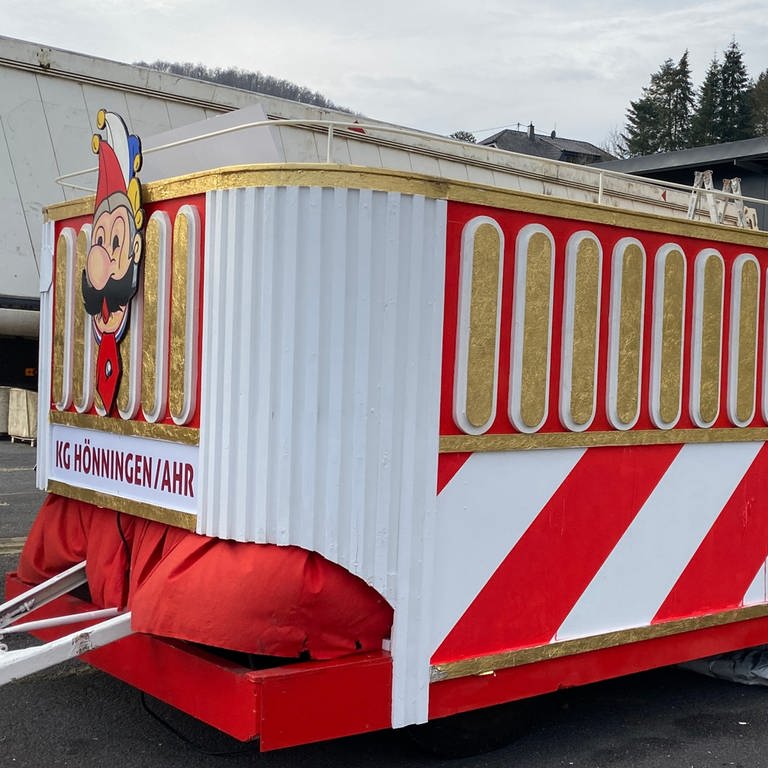 Der neue, gespendete Karnevalswagen der KG Rot-Weiss Hönningen in rot-weiß gestreift mit goldenen Details und mit einem Turm und Wappen verziert (Foto: SWR)