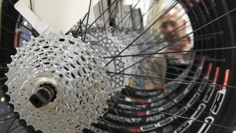 Hinterräder eines Fahrrads der Marke Canyon werden von einem Mitarbeiter begutachtet (Foto: picture-alliance / Reportdienste, Thomas Frey)