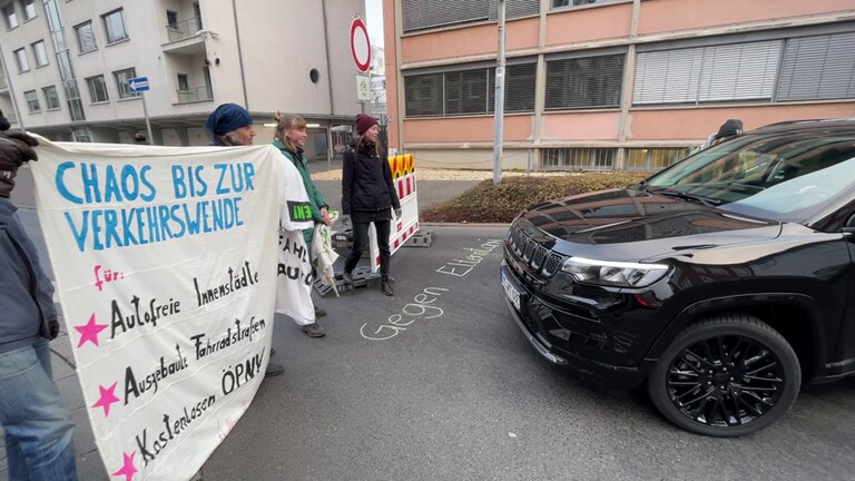 Schwarzer SUV steht direkt vor der Absperrung in die Koblenzer Rizzastraße in der eine Demonstration stattfindet (Foto: SWR)
