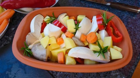 Ein Römertopf mit Gemüse gefüllt