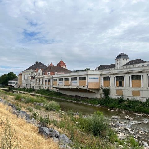Ein Flussufer mit einem Gebäude. Der Kurpark in Bad Neuenahr-Ahrweiler wurde durch die Wassermassen stark beschädigt. Unter anderem wurde eine Brücke weggerissen. 