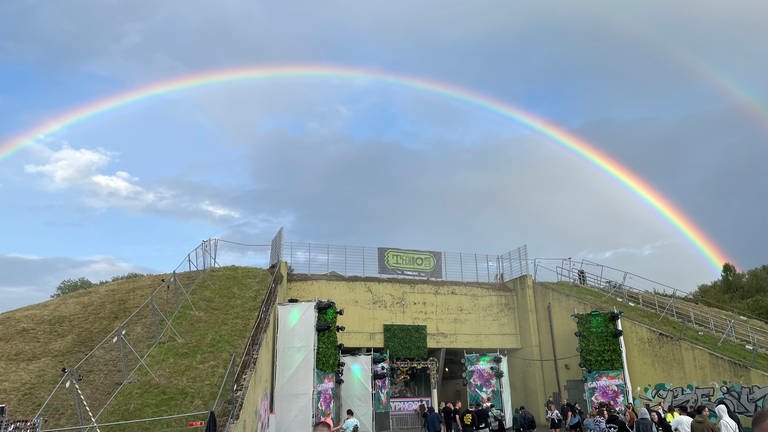 Das Wetter beim Techno-Festival NATURE ONE im Hunsrück ist nicht hochsommerlich, aber dafür mit spektakulärem Regenbogen.