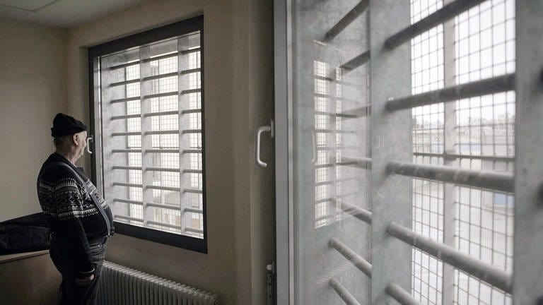 Der als Doppelmörder verurteilte Klaus Bräunig steht vor vergitterten Fenstern im Gefängnis