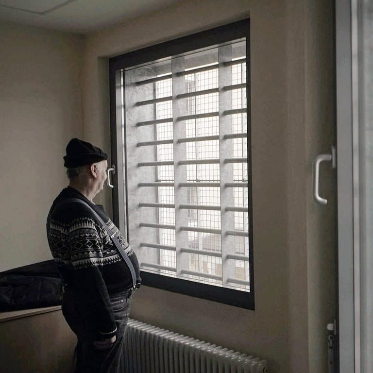 Der als Doppelmörder verurteilte Klaus Bräunig steht vor vergitterten Fenstern im Gefängnis (Foto: SWR)