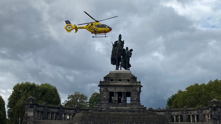 Rettungshubschrauber Christoph 23 aus Koblenz fliegt über dem Kaiserdenkmal am Deutschen Eck. (Foto: SWR)