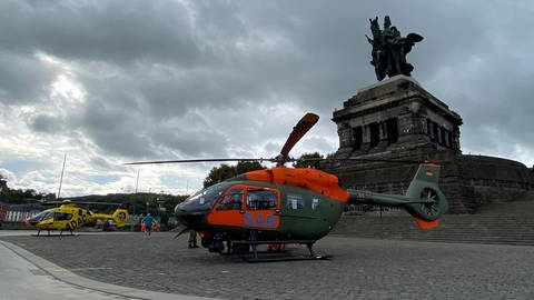 Der ADAC-Rettungshubschrauber und ein Rettungshubschrauber der Bundeswehr stehen vor dem Kaiserdenkmal am Deutschen Eck in Koblenz.
