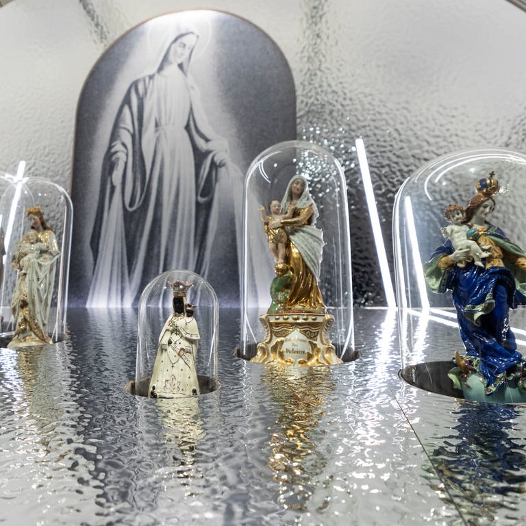 Mehrere Madonnenfiguren auf einem blauen Tisch vor einem blauen Hintergrund: Im Landesmuseum auf der Festung Ehrenbreitstein sind in einer Sonderausstellung jetzt 200 Madonnenfiguren zu sehen (Foto: GDKE Rheinland-Pfalz / Kulbe)