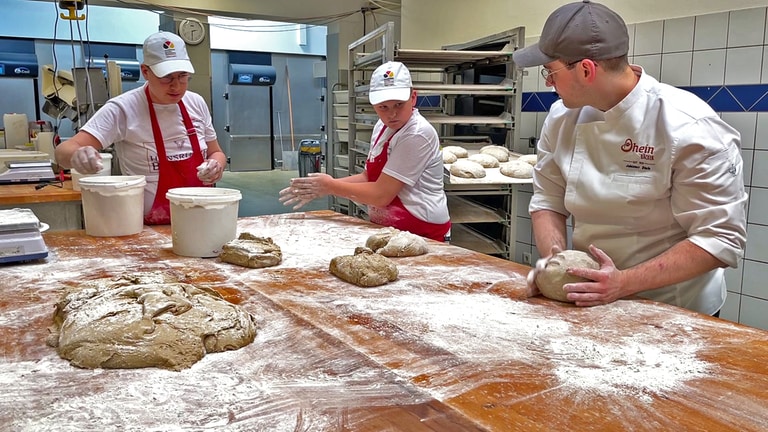 Clemens Wiede und Janic Schmitt lernen bei Bäckermeister Johannes Dhein, wie man Sauerteig-Brot backt (Foto: SWR)