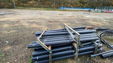 Baurohre liegen auf dem ehemaligen Sportplatz in Dernau, der künftig Überschwemmungsfläche für die Ahr werden soll. (Foto: SWR)